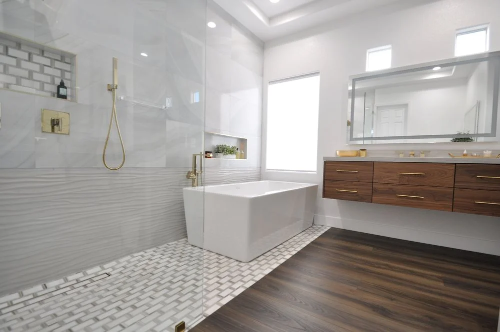 Bright bathroom with a tiled shower, freestanding tub, and floating wood vanity
